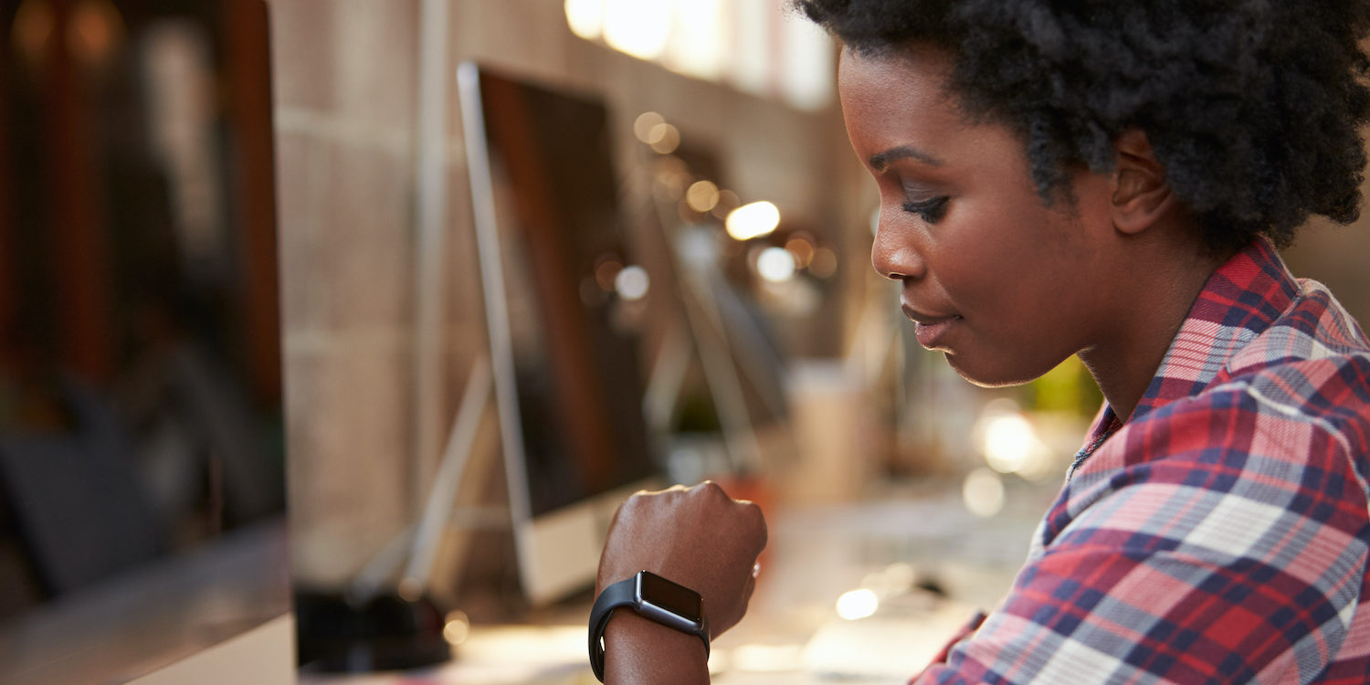 A woman in supply chain using a wearable device by allegiance staffing.
