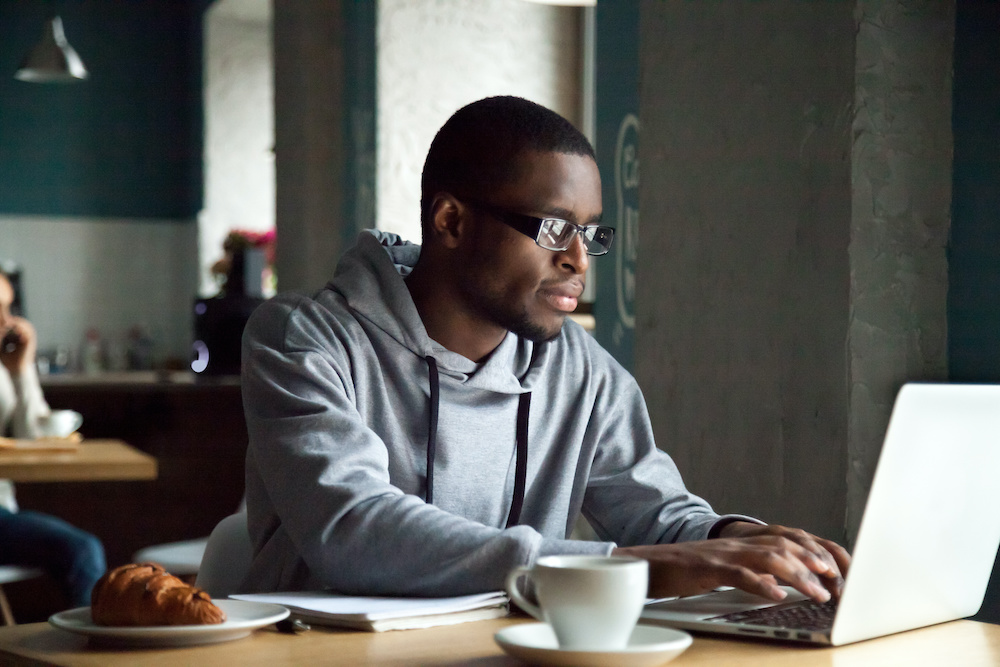 Young man using laptop to find a new job quickly by allegiance staffing
