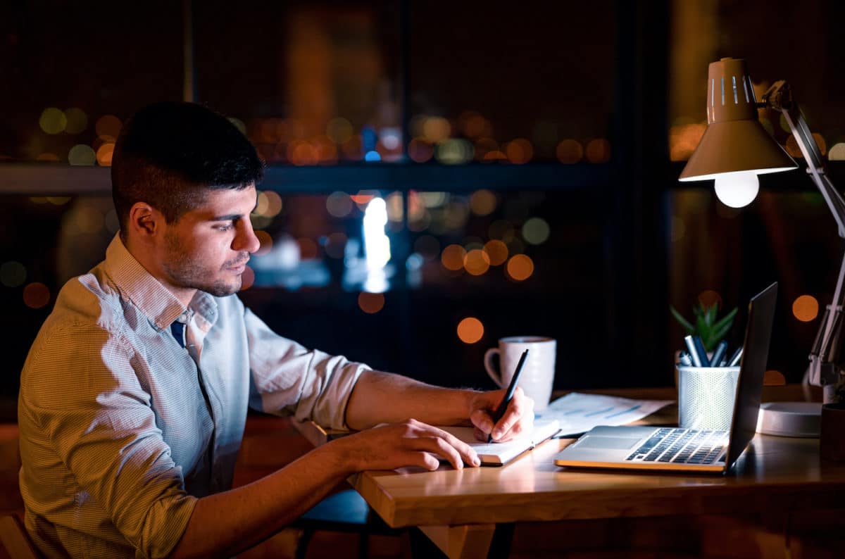 A man working at his desk during his part time overnight job