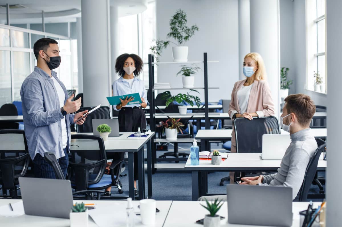 8 Ways to Stay Safe At Work During the Pandemic 1 A fully staffed workplace practicing social distancing and wearing masks by allegiance staffing in houston, texas.