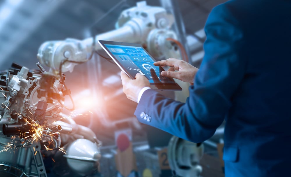 3 Things to Consider When Hiring Manufacturing Positions 1 Manufacturing manager using technology to move a robot after hiring for other manufacturing positions
