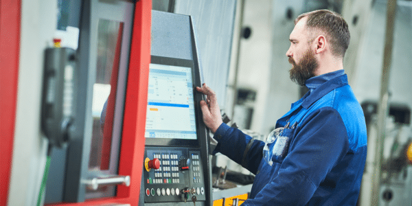 CNC Operator Salary and Job Description 4 A man working in a machine shop after learning more about a CNC operator salary