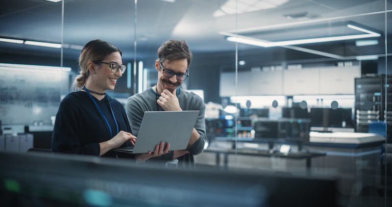 Two colleagues in the office looking at a laptop