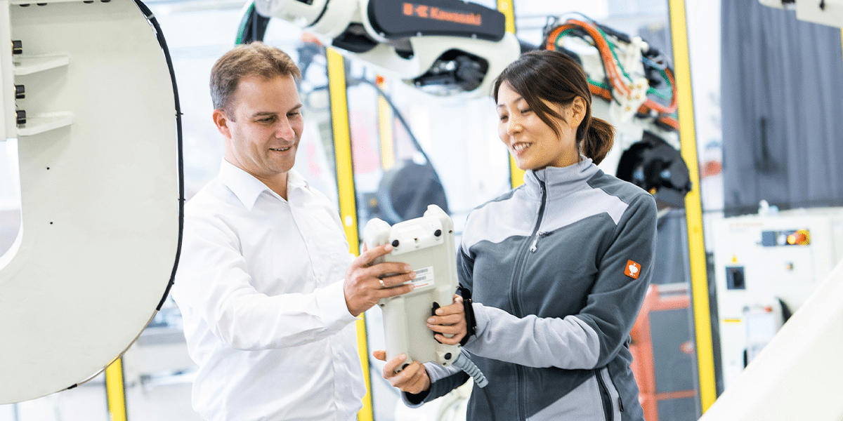 Manufacturing workers using a tablet to perform daily tasks