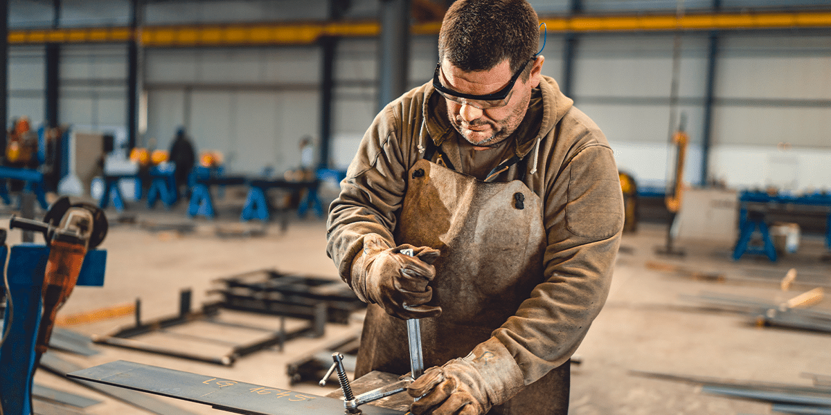 Industrial worker using machinery in a shop to perform key duties